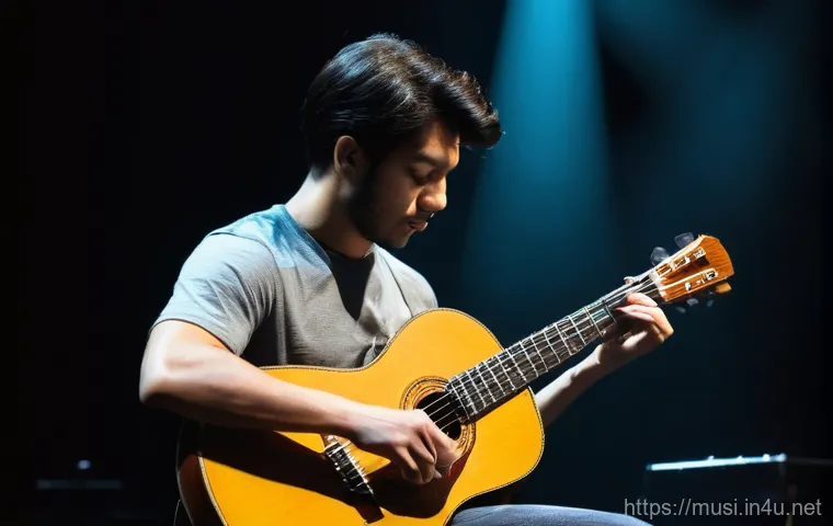 기타 핑거스타일 기법 - A male fingerstyle guitarist, in his late 20s, performing intensely on a dimly lit stage with a spot...