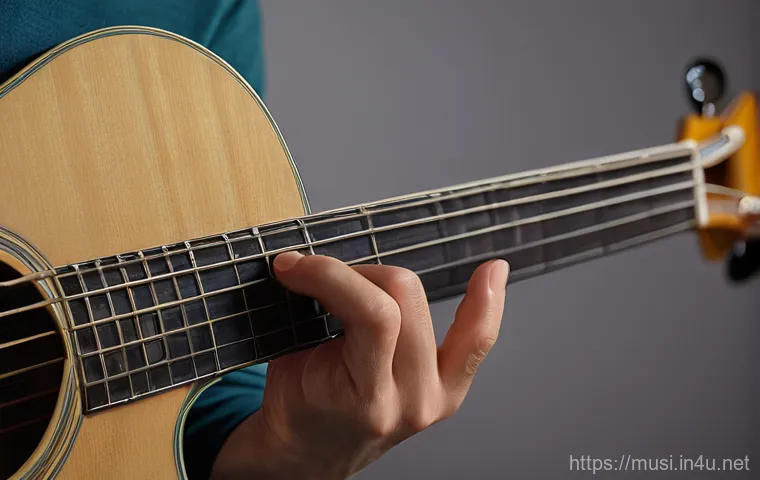 기타 핑거스타일 기법 - A male fingerstyle guitarist, in his late 20s, performing on a dimly lit stage with a single spotlig...