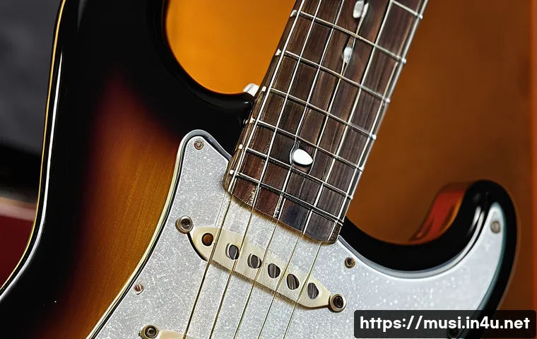 기타 픽업 종류 설명 - A close-up, high-resolution image of a traditional single-coil guitar pickup mounted on a classic Fe...